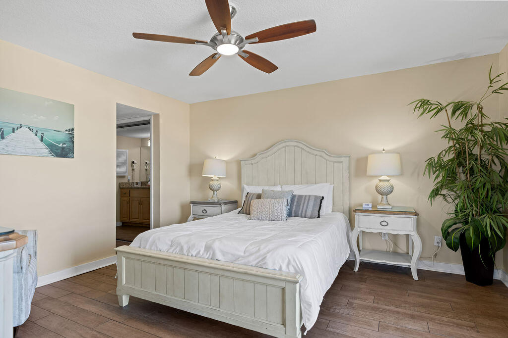 909 Santa Rosa Boulevard, Unit 569 Fort Walton Beach, FL 32548 - Photo 20 of 57 a bedroom with a large bed wooden floor and a chandelier