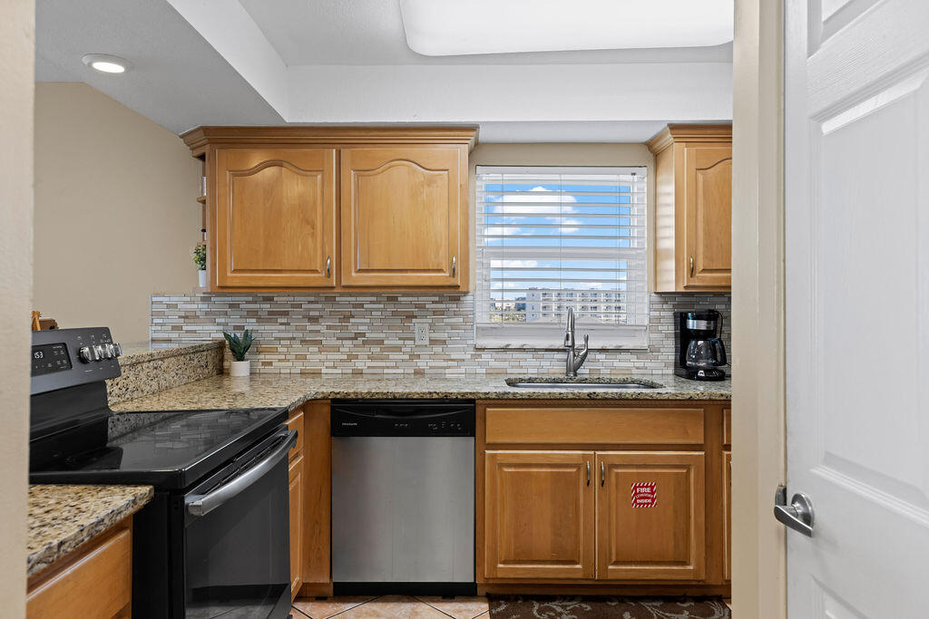 909 Santa Rosa Boulevard, Unit 569 Fort Walton Beach, FL 32548 - Photo 32 of 57 a kitchen with stainless steel appliances granite countertop a sink stove and cabinets