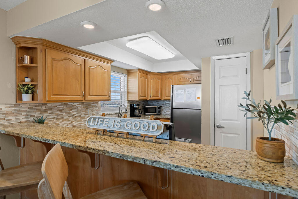 909 Santa Rosa Boulevard, Unit 569 Fort Walton Beach, FL 32548 - Photo 37 of 57 a kitchen with stainless steel appliances granite countertop a refrigerator a stove and a sink