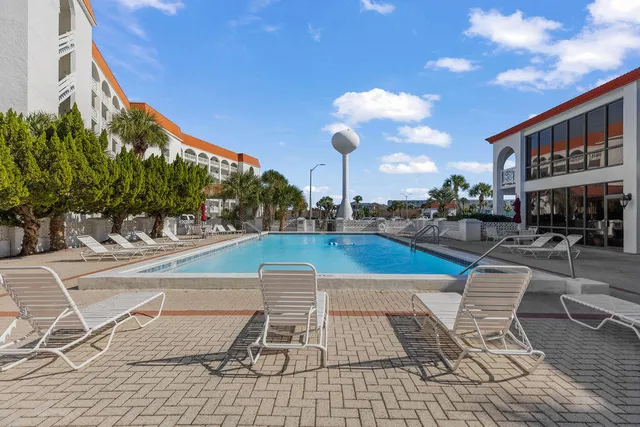a view of a tennis ground with large trees
