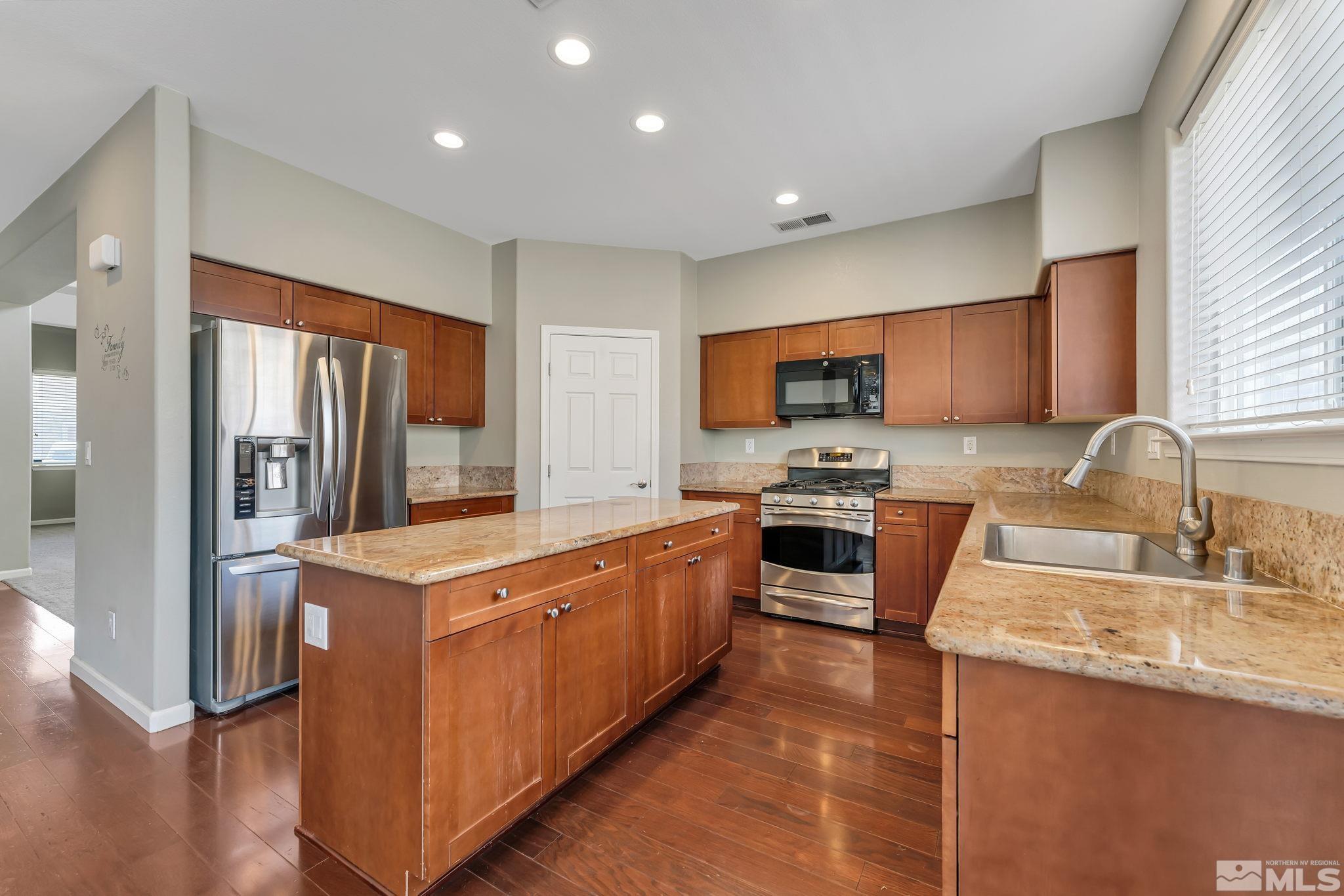 3720 Thistledown Court Reno, NV 89512 - Photo 6 of 8 a kitchen with stainless steel appliances granite countertop a stove top oven a sink and a refrigerator