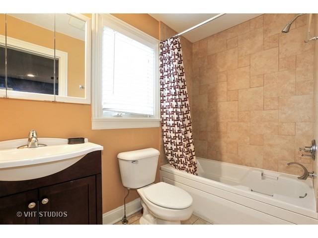 888 Spring Road Elmhurst, IL 60126 - Photo 17 of 22 a bathroom with a sink toilet a mirror and shower