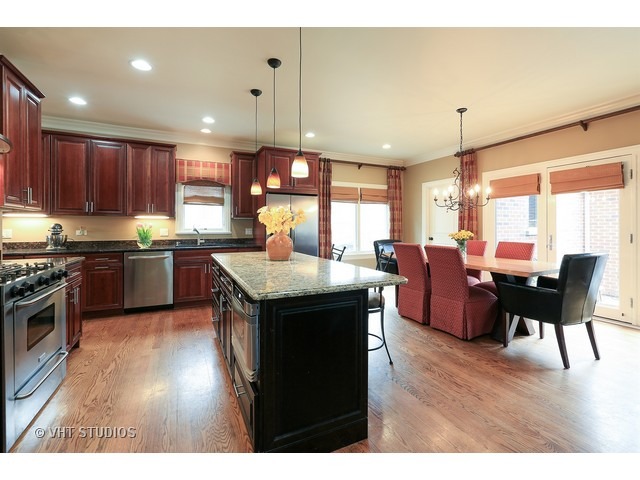 888 Spring Road Elmhurst, IL 60126 - Photo 7 of 22 a kitchen with stainless steel appliances granite countertop wooden cabinets a stove a sink a dining table and chairs