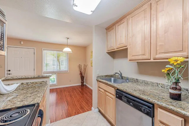 a kitchen with granite countertop stainless steel appliances window a sink and cabinets
