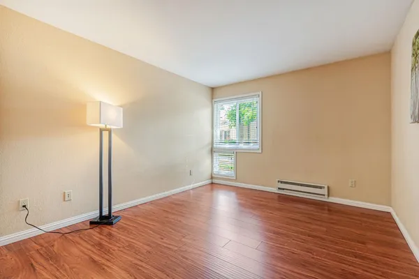 an empty room with wooden floor and windows