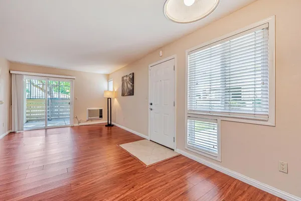 an empty room with wooden floor and windows