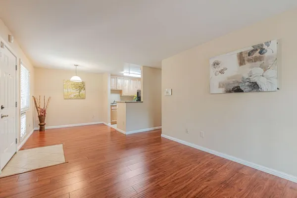 a view of a kitchen with wooden floor and a refrigerator