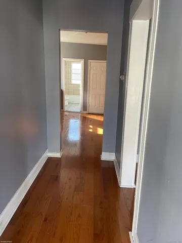 a view of a hallway with wooden floor