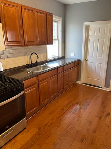 a kitchen with stainless steel appliances granite countertop a sink stove and cabinets