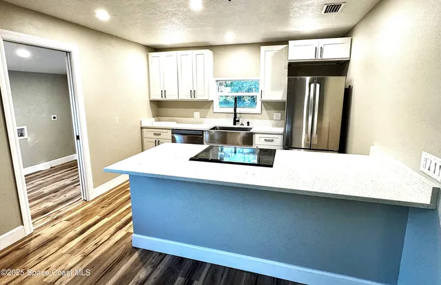 a kitchen with stainless steel appliances a refrigerator and wooden cabinets