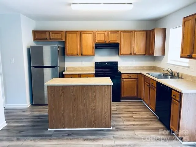 a kitchen with stainless steel appliances granite countertop a stove a refrigerator and a sink