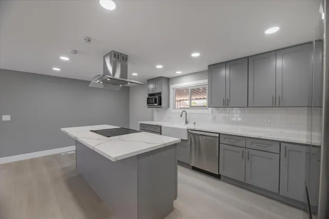 a kitchen with a sink vanity and stainless steel appliances