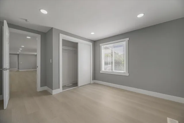 an empty room with windows and closet