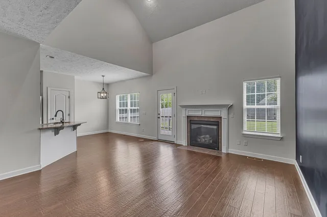 a view of a big room with wooden floor and a kitchen