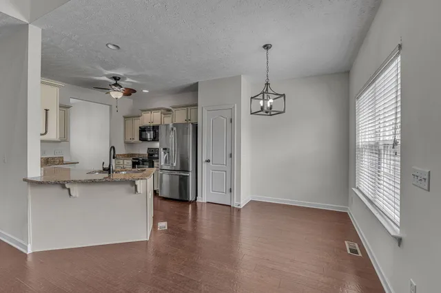 a large kitchen with a lot of counter space and wooden floor