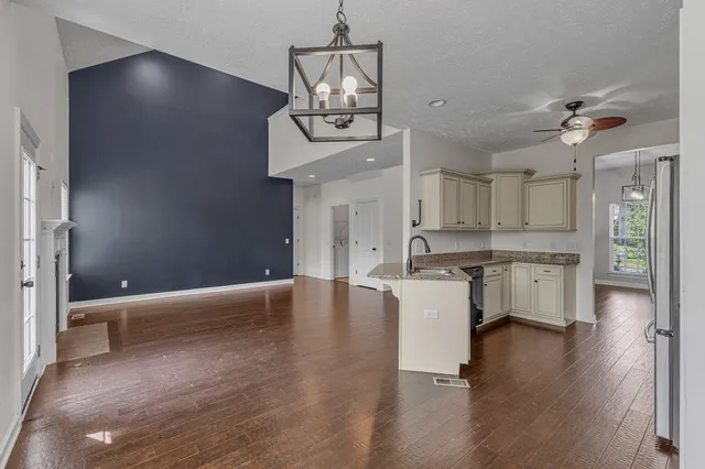 a kitchen with stainless steel appliances granite countertop a refrigerator a sink a stove with cabinets