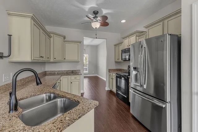 a kitchen with stainless steel appliances granite countertop a stove a sink and a refrigerator