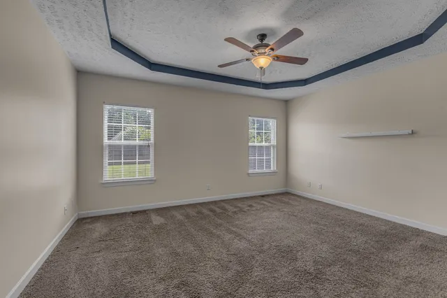 en empty room with fan and a ceiling fan