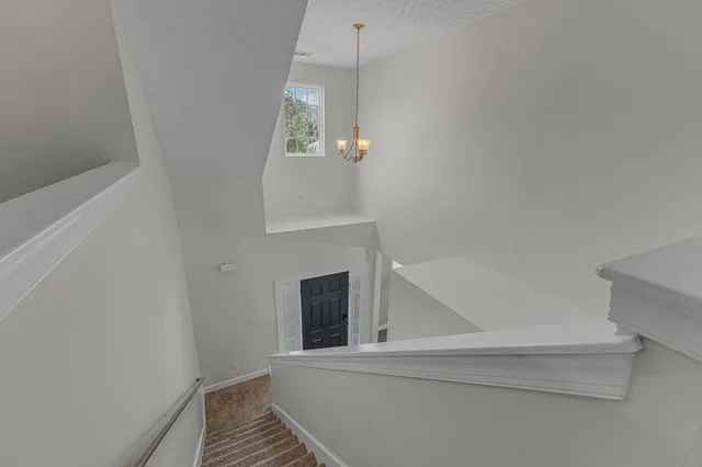 a view of a hallway to rooms and stairs