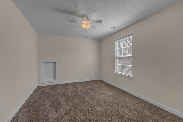 an empty room with a chandelier fan