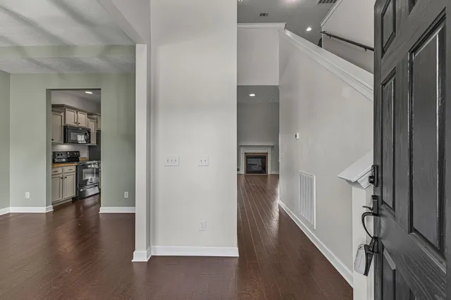 an empty room with wooden floor closet and windows