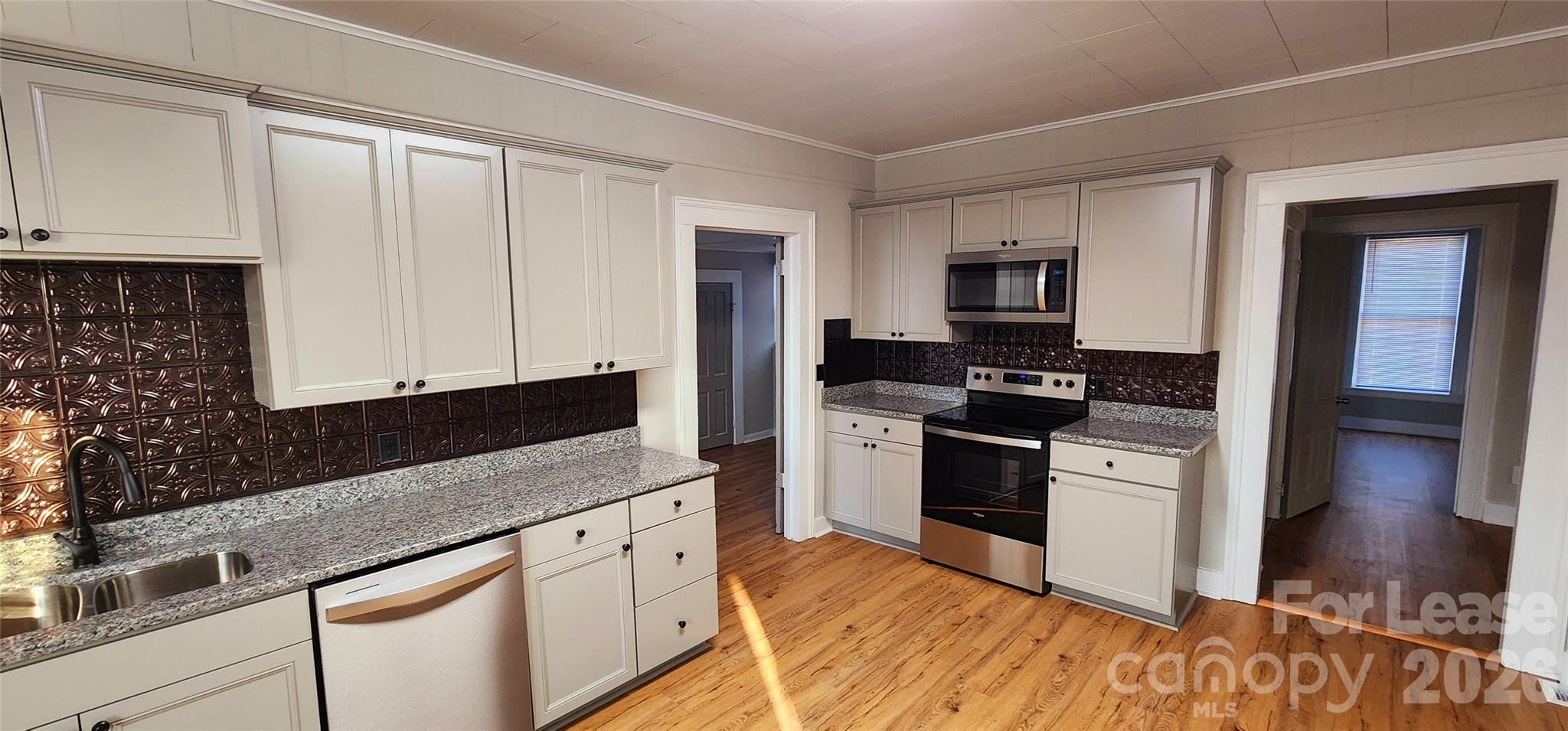 359 Flat Rock Road Lawndale, NC 28090 - Photo 10 of 19 a kitchen with granite countertop a stove a sink and a microwave