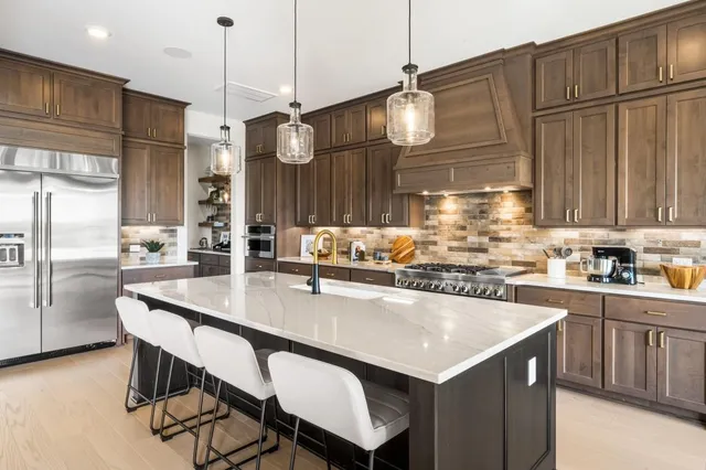 a kitchen with granite countertop a table chairs stainless steel appliances and cabinets