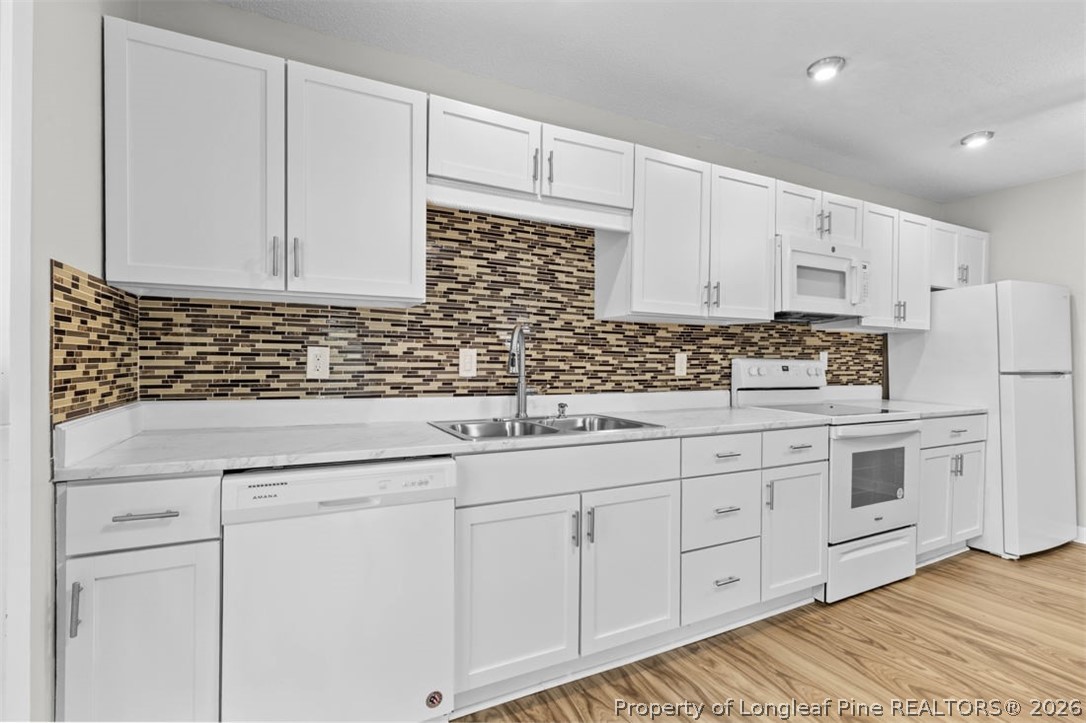 3305 Hunting Bay Drive Spring Lake, NC 28390 - Photo 13 of 27 a kitchen with white cabinets sink and white appliances