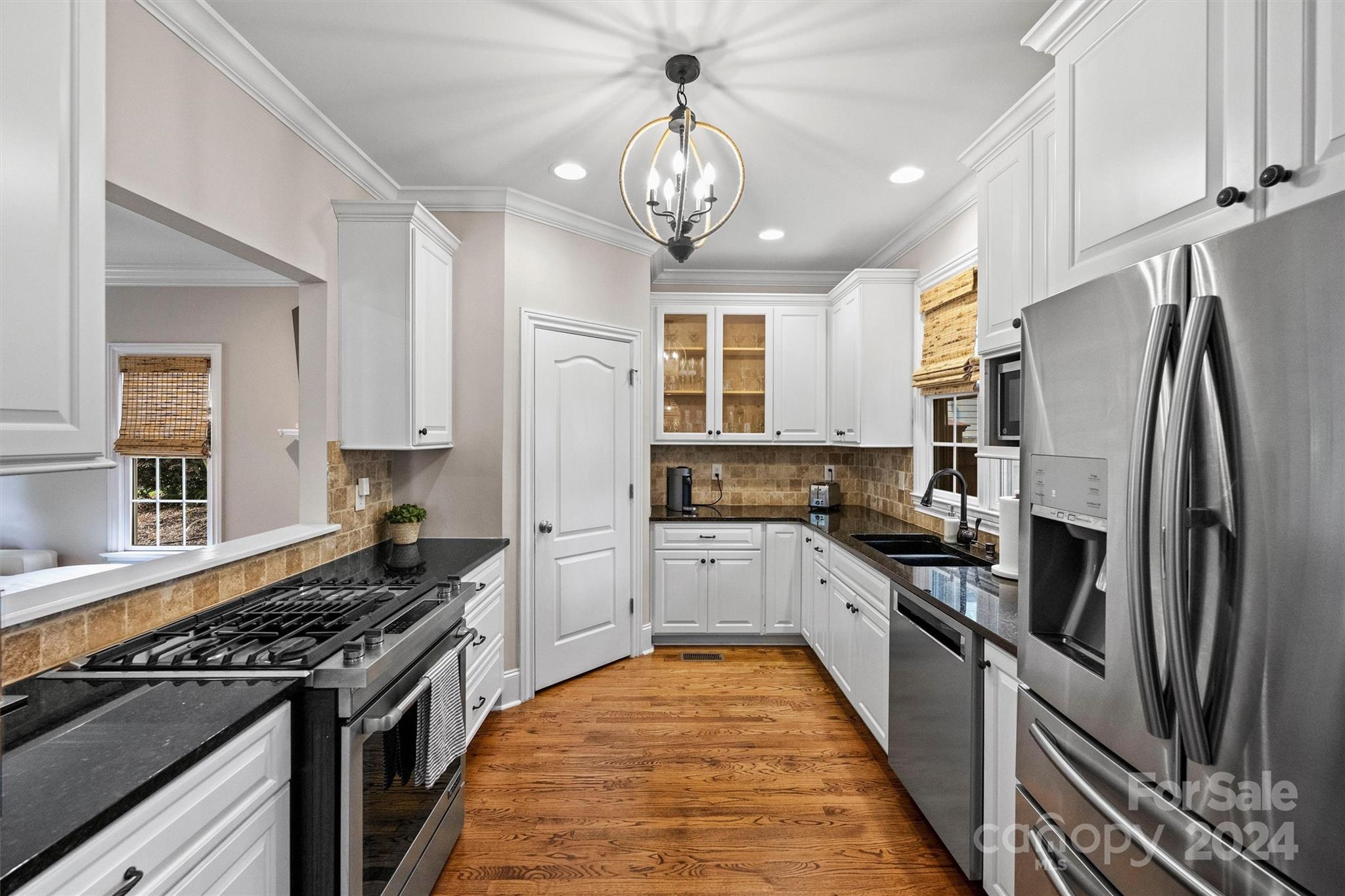 813 Millbrook Road Charlotte, NC 28211 - Photo 15 of 47 a kitchen with stainless steel appliances granite countertop a stove top oven a sink dishwasher a refrigerator and a dining table with wooden floor