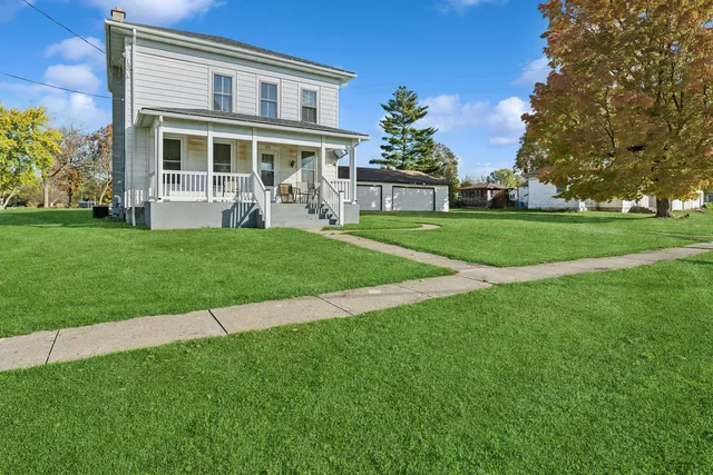 a front view of a house with a yard and trees