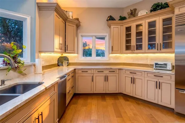 a kitchen with stainless steel appliances kitchen island granite countertop a table chairs and a refrigerator