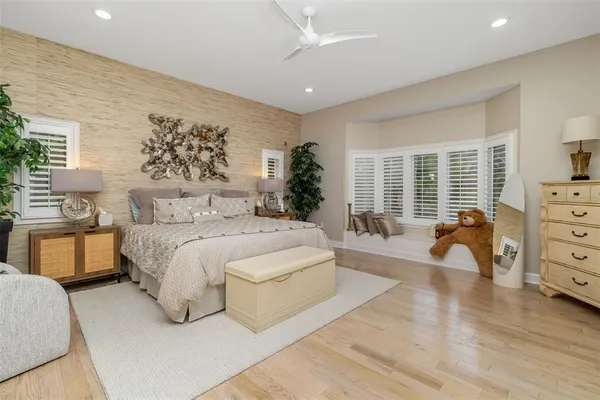 a bedroom with a large bed and a potted plant