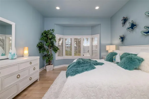 a room with stainless steel appliances kitchen island granite countertop a dining table chairs and a refrigerator