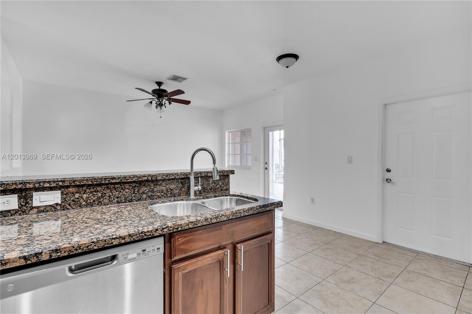 14044 Southwest 273rd Lane, Unit 14044 Homestead, FL 33032 - Photo 13 of 44 a bathroom with a granite countertop sink a mirror and vanity