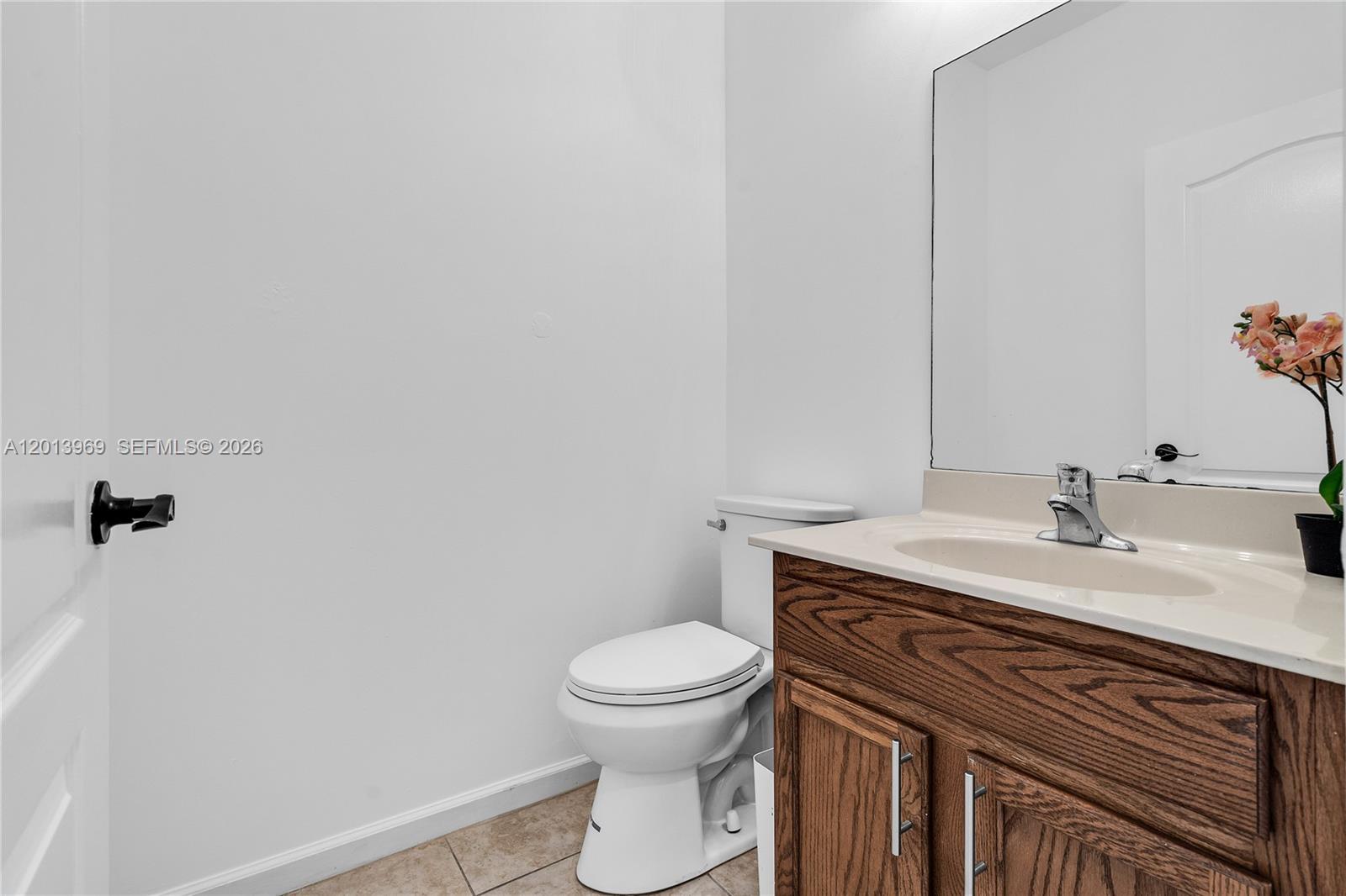 14044 Southwest 273rd Lane, Unit 14044 Homestead, FL 33032 - Photo 14 of 44 a bathroom with a granite countertop toilet sink and mirror
