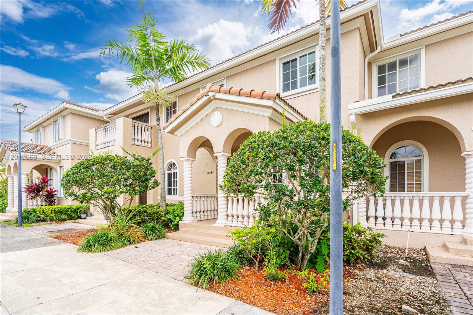 14044 Southwest 273rd Lane, Unit 14044 Homestead, FL 33032 - Photo 3 of 44 a front view of a house with a garden
