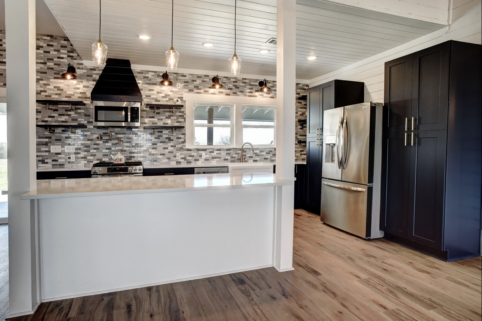4165 Pin Oak Road Muldoon, TX 78949 - Photo 11 of 44 Kitchen featuring stainless steel appliances, decorative backsplash, open shelves, and light wood finished floors