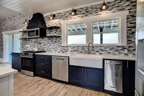 a kitchen with stainless steel appliances kitchen island granite countertop a sink stove and oven