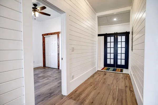 a view of a hallway with wooden floor and a window