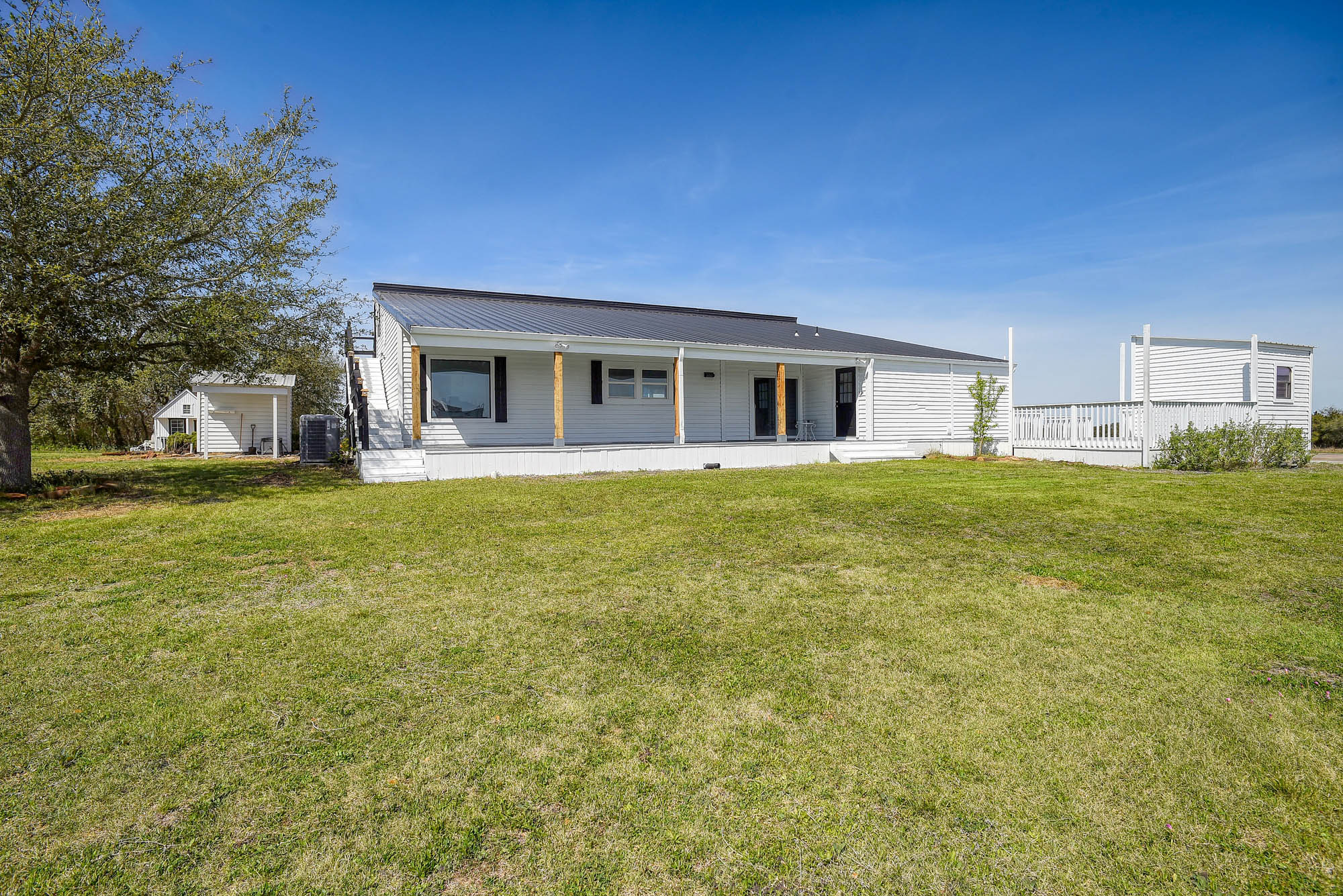 4165 Pin Oak Road Muldoon, TX 78949 - Photo 29 of 44 Rear view of house with a porch, a yard, and a metal roof