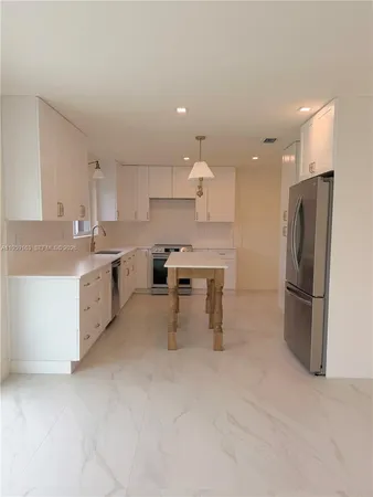 a kitchen with stainless steel appliances a refrigerator sink and cabinets