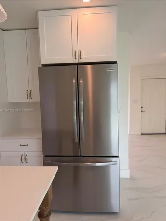 a white refrigerator freezer sitting in a kitchen
