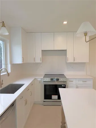 a kitchen with a stove a sink and a refrigerator