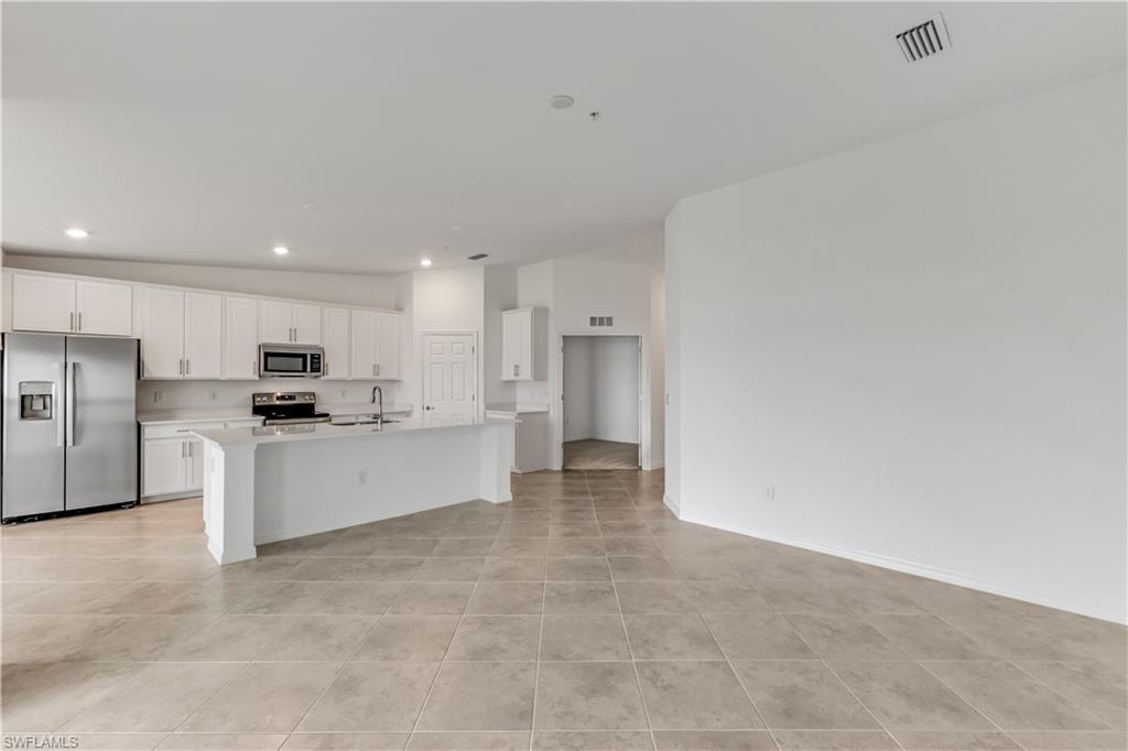 15950 Grassland Lane, Unit 2623 Babcock Ranch, FL 33982 - Photo 12 of 16 a large white kitchen with white cabinets and stainless steel appliances
