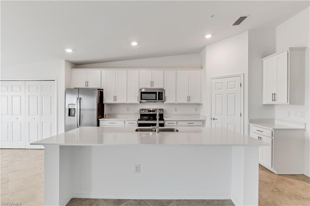 15950 Grassland Lane, Unit 2623 Babcock Ranch, FL 33982 - Photo 7 of 16 a kitchen with kitchen island a counter top space stainless steel appliances and cabinets