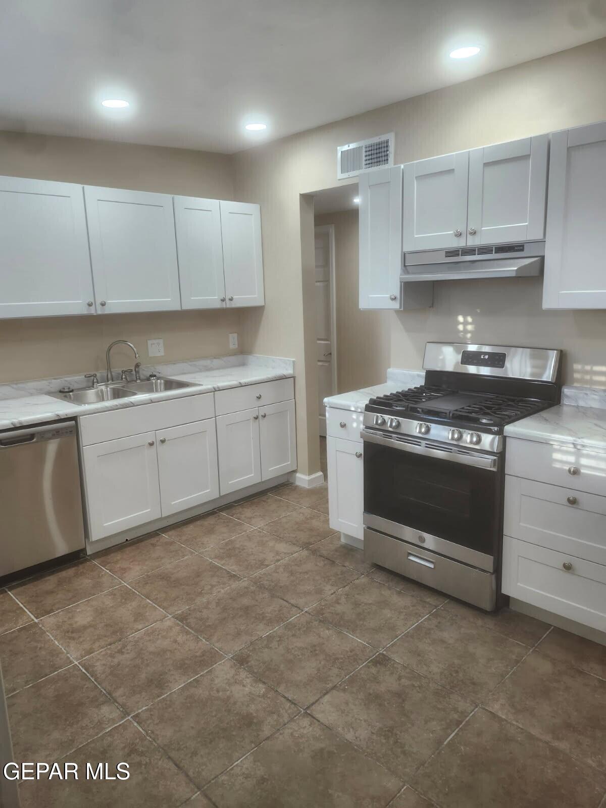 6227 Algonquin Road El Paso, TX 79905 - Photo 3 of 14 a kitchen with granite countertop a stove top oven sink and cabinets