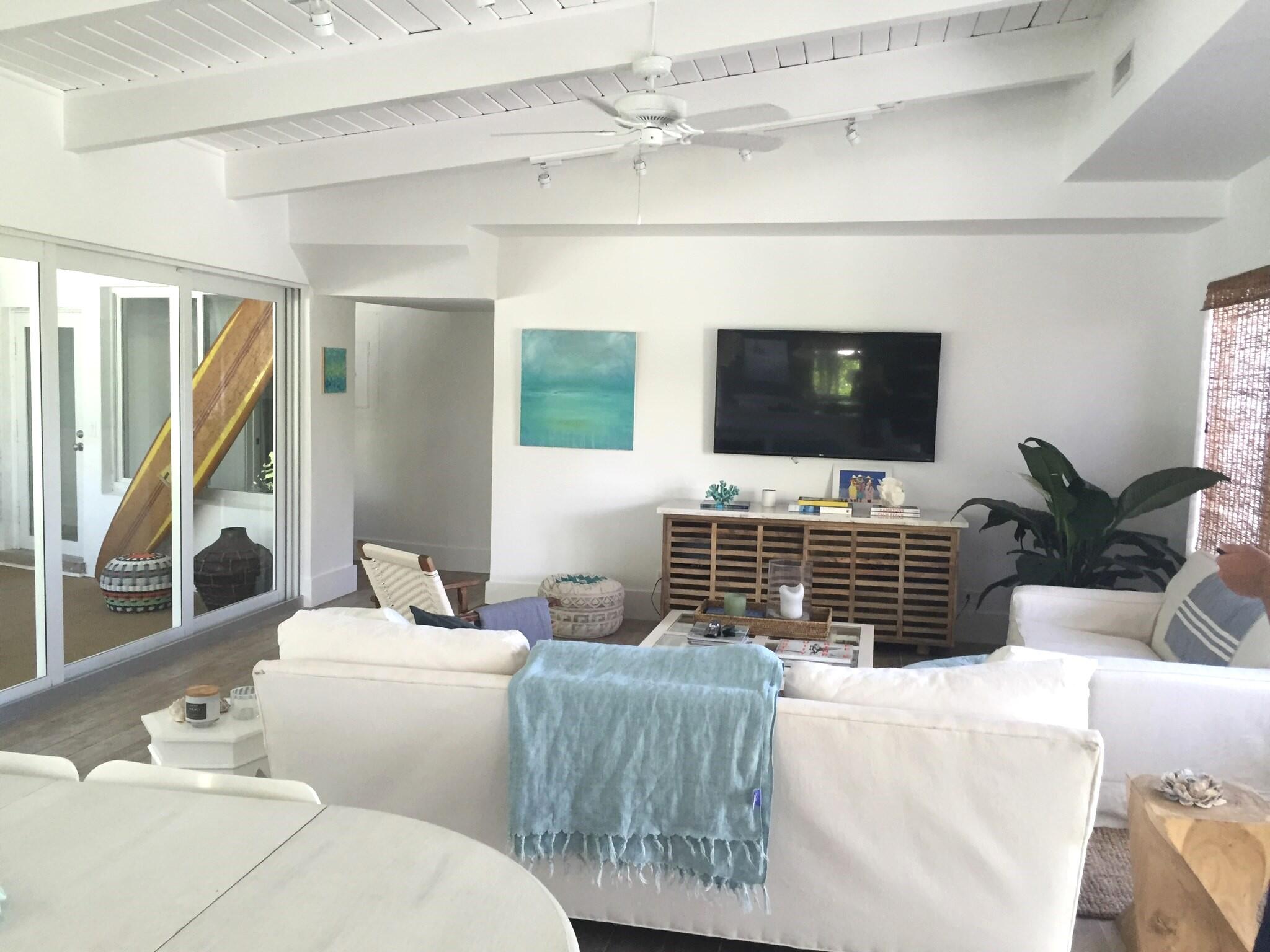 145 Beacon Lane Jupiter Inlet Colony, FL 33469 - Photo 3 of 15 a living room with furniture a flat screen tv and a floor to ceiling window