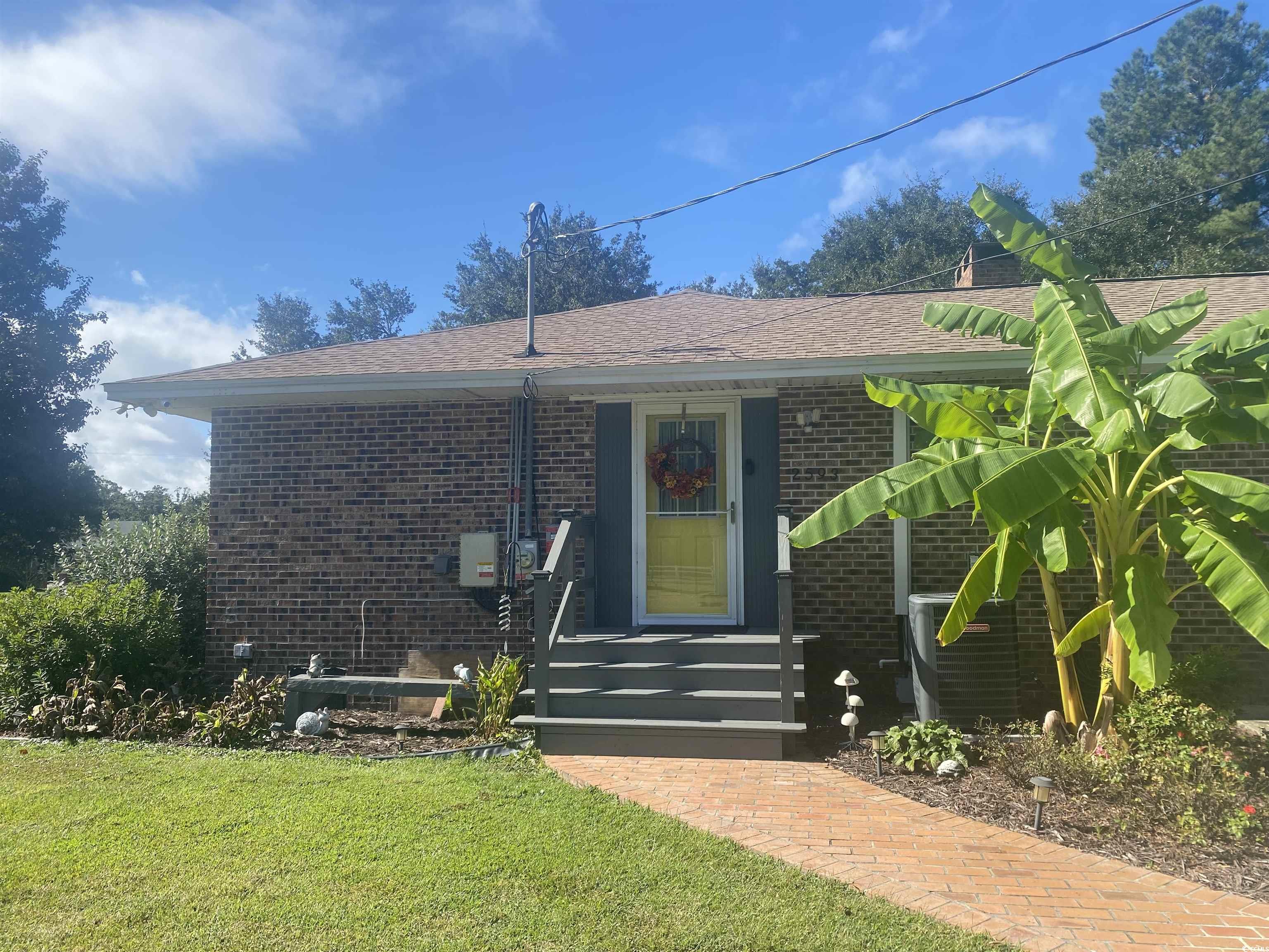 2593 Long Ave Extension Conway, SC 29526 - Photo 17 of 40 Doorway to property with brick siding, roof with shingles, and a lawn