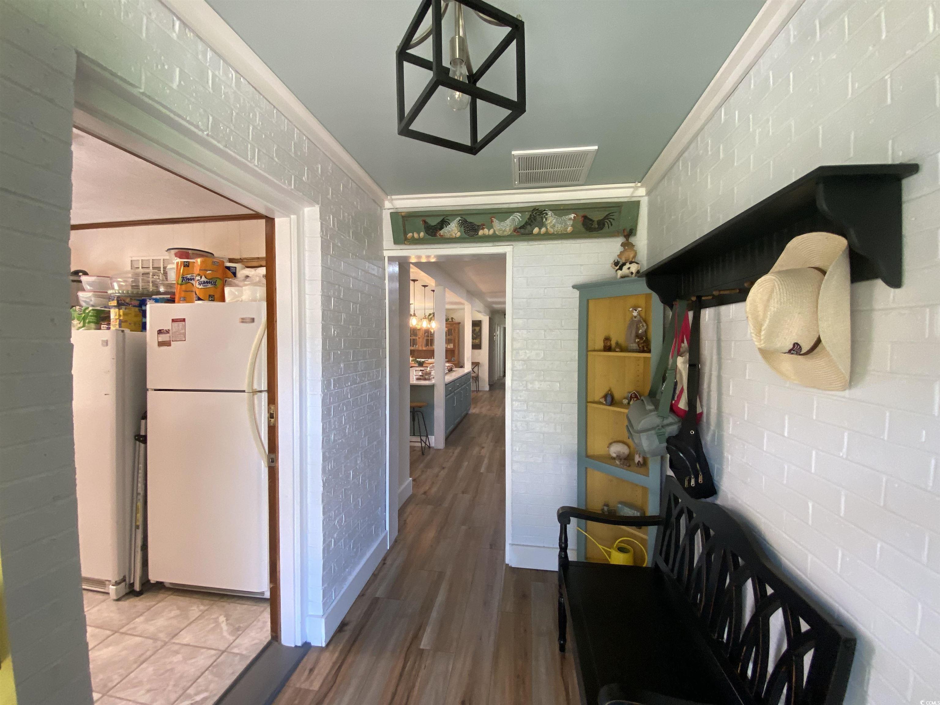 2593 Long Ave Extension Conway, SC 29526 - Photo 19 of 40 Mudroom featuring crown molding, brick wall, a chandelier, and dark wood finished floors