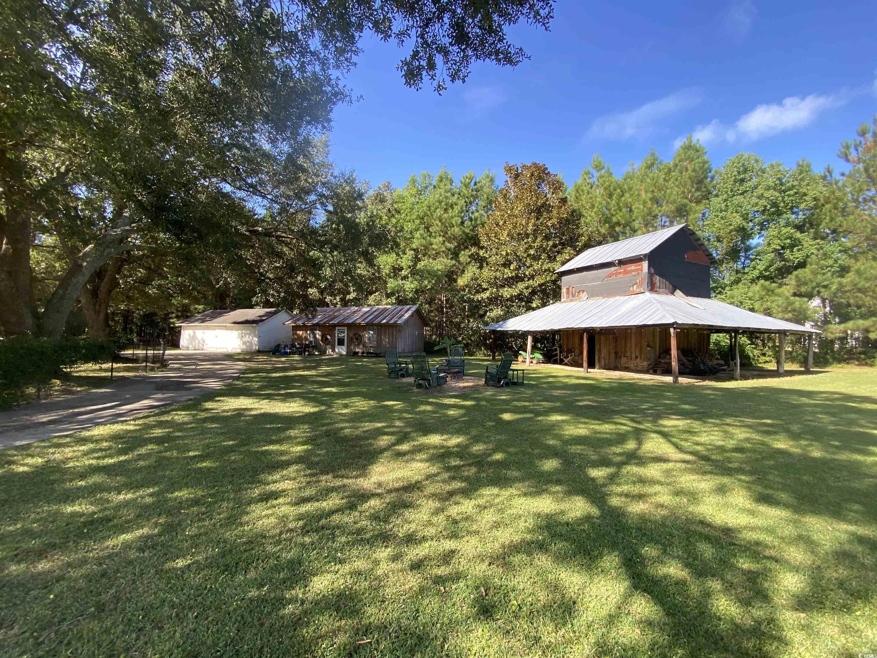 2593 Long Ave Extension Conway, SC 29526 - Photo 7 of 40 View of green lawn with an outbuilding and view of wooded area
